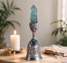 Charger l'image dans la galerie, Crystal bell chime with fluorite crystal placed on a wooden meditation table beside a lit white candle, dried flowers, folded scripture and sheer fabric, soft natural light and greenery – calming meditation and healing décor