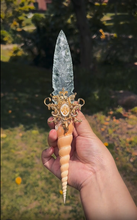 Load image into Gallery viewer, Macro close-up of the dagger's hilt, featuring a genuine ammonite fossil, shimmering abalone shell, and an ornate bronze cap