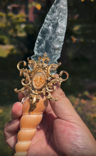 Load image into Gallery viewer, Hand holding the unique Crystal Ritual Dagger, displaying the full length and ergonomic design of the fossil and glass handle